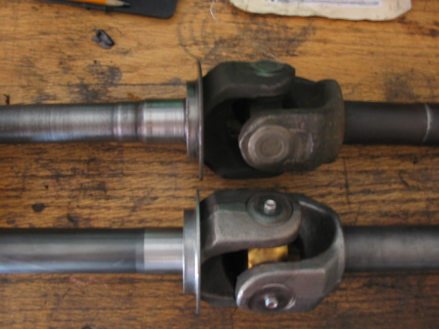 Two driveshafts with U-joints on a wooden bench