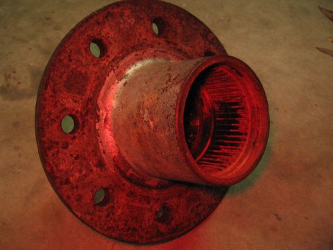 1974 Ford F-100 - A close-up view of a rusty wheel hub, showing its splined interior and bolt mounting holes.
