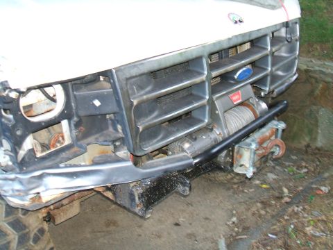 1995 Ford Bronco - Front view of a Ford truck's grille and bumper, modified with a winch.