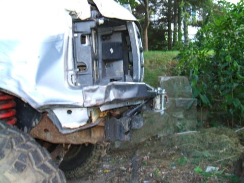 1995 Ford Bronco - The rear of a 1995 Ford Bronco shows significant damage to the bumper and bodywork, with suspension components visible.