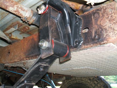 1995 Ford Bronco - Underside view of a vehicle's suspension system, showing rusty metal and new black components.