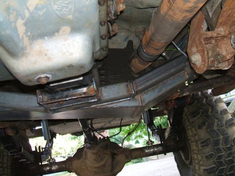 1995 Ford Bronco - The underside of a vehicle shows its engine, transmission, and suspension components with some modifications.