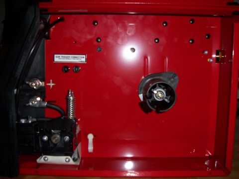 1983 Ford Bronco - Close-up view of the internal components of a red welding machine, including the wire spool and connection points.