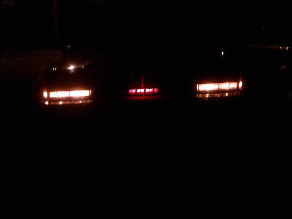 three cars' taillights illuminated at night
