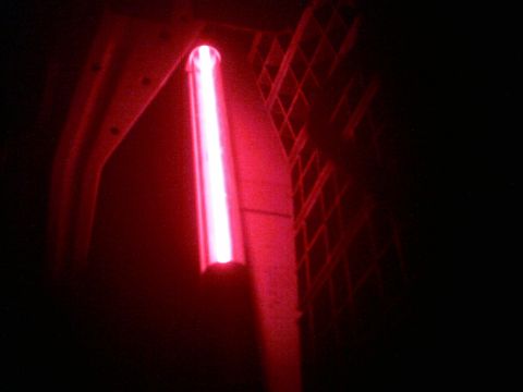 1985 Ford Crown Victoria LTD - A red light tube is illuminated against a dark background, with a diamond pattern grille on the right.
