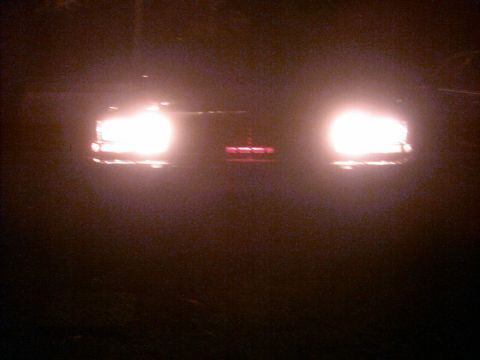 1985 Ford Crown Victoria LTD - Front view of a 1985 Ford Crown Victoria LTD with headlights on at night.