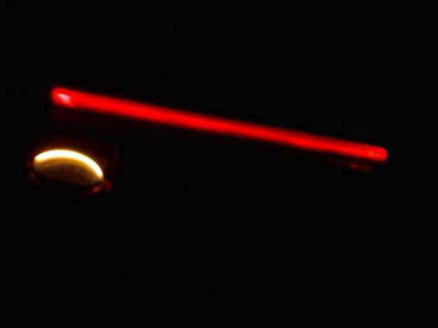 1985 Ford Crown Victoria LTD - A close-up view of a red illuminated gauge needle against a dark background.