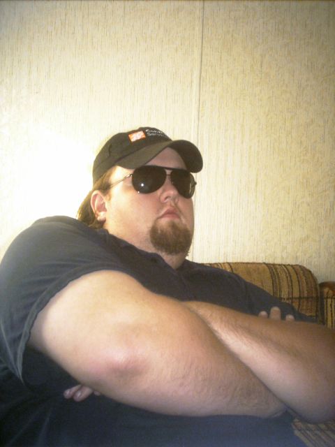1985 Ford Crown Victoria LTD - A man wearing a baseball cap and sunglasses sits with his arms crossed.