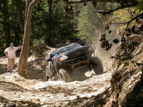 1990 Ford Bronco - A black Ford F-150 SVT Lightning navigates a challenging off-road course.