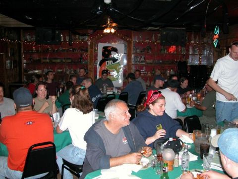 1997 Jeep TJ - A lively indoor scene captures patrons enjoying a meal and drinks in a crowded establishment.