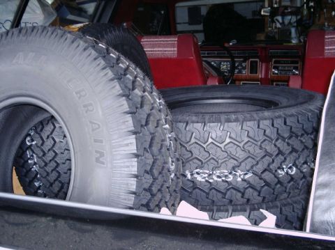 1984 Ford Bronco - Spare tires are stored inside the interior of a vehicle, obscuring most of the dashboard and seats.
