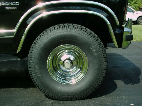 1984 Ford Bronco - Close-up of a 1984 Ford Bronco's side fender and wheel assembly.