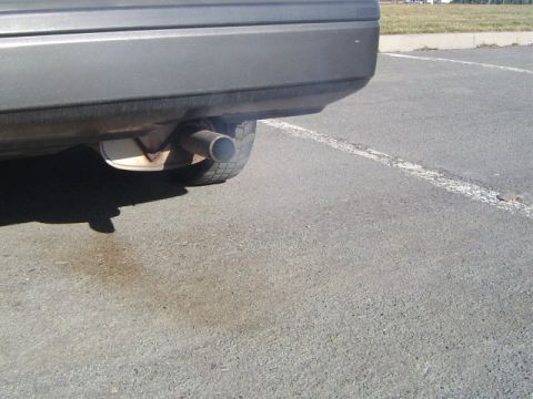 1986 Honda Accord - Close-up view of a car's exhaust pipe and rear tire.