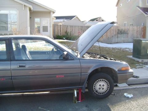 1986 Honda Accord - A gray Honda Accord is parked in a driveway with its hood open and the front end raised on jack stands.