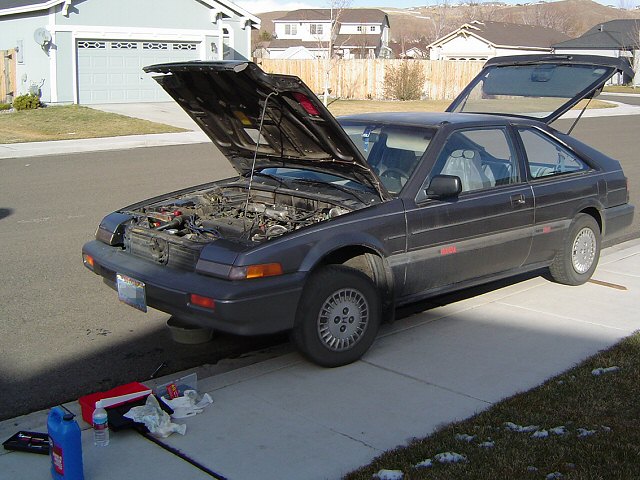 Dark gray 1986 Honda Accord coupe with hood and trunk open, parked on a residential street