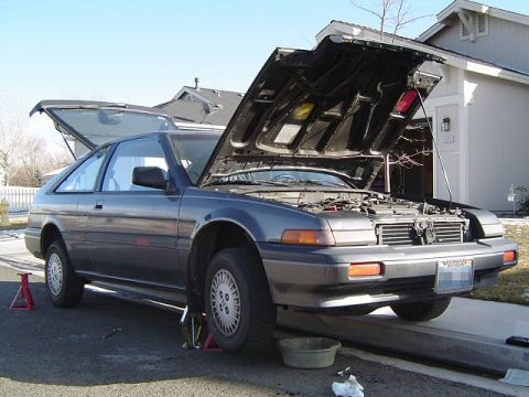 1986 Honda Accord - Gray 1986 Honda Accord hatchback with hood and trunk open, parked on jack stands for maintenance.