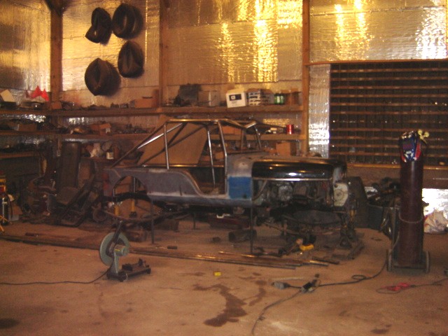 Side view of a vehicle chassis with a roll cage, undergoing construction
