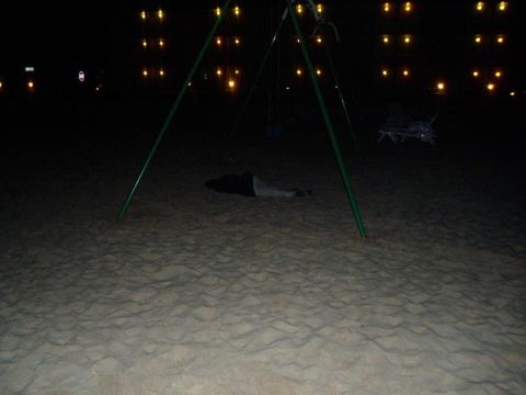 1992 Ford Bronco - Nighttime scene on a sandy area with a swing set and distant lights.