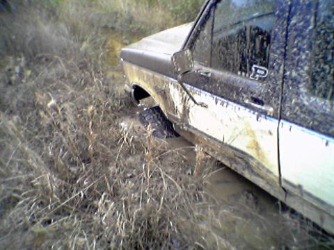 1991 Ford F-150 - This 1991 Ford F-150 is seen stuck in a muddy area, with its side heavily covered in mud.