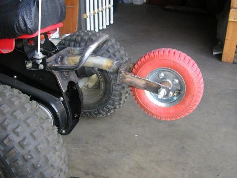 1900 Honda Big Red - Close-up of an ATV's rear axle modification a small red wheel.