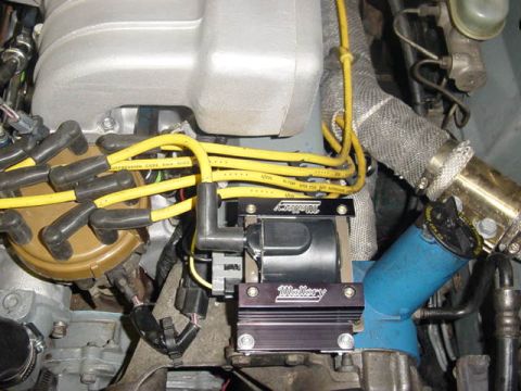 1995 Ford Mustang - Engine bay detail showing spark plug wires and an aftermarket ignition coil.