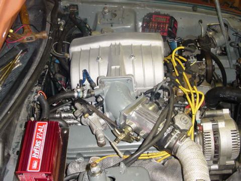 1995 Ford Mustang - Close-up view of a car's engine bay, showing various components and wiring.