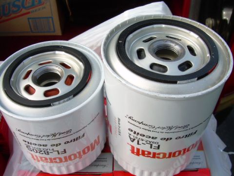 1988 Ford Bronco - Two new white Motorcraft spin-on oil filters standing gasket-side up on their red boxes, the larger FL-1A (D9AZ-6731A) beside a smaller FL-…