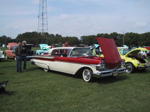 1968 Shelby GT500 - Two-tone 1957 Mercury Montclair with hood open at a car show, next to a yellow VW Beetle.
