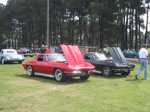 1968 Shelby GT500 - Two classic Corvettes are displayed with their hoods open at an outdoor event.
