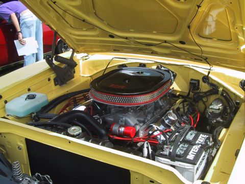 1968 Shelby GT500 - The engine bay of a yellow car is open, revealing a V8 engine with a prominent air cleaner.