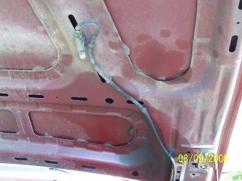 1992 Ford Bronco - The underside of a red hood shows wiring and a visible date stamp from 2006.