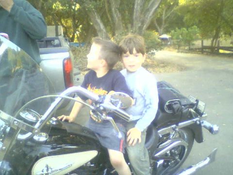 1986 Ford Bronco - Two children sit on a motorcycle, looking off to the side.