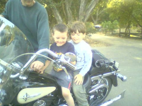 1986 Ford Bronco - Two young boys and an adult pose on a motorcycle, with the front of the bike and handlebars clearly visible.