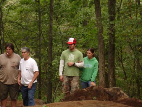 1996 Ford Bronco - A group of people are gathered in a forest clearing, with dirt piles visible.