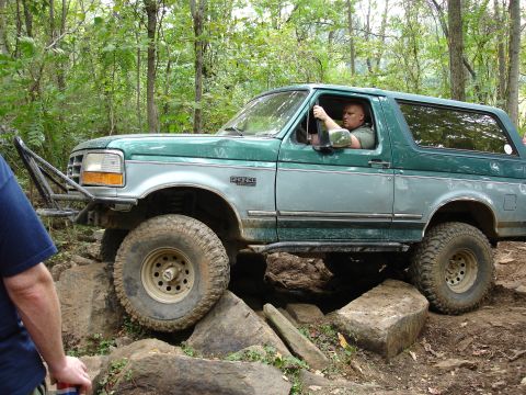 1996 Ford Bronco - A 1996 Ford Bronco navigates a rocky trail, demonstrating its off-road capabilities.