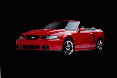 2003 Ford Mustang - Red 2003 Ford Mustang convertible with the top down, shown from a 3/4 front angle.