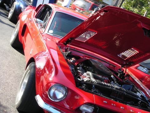 1992 Ford Crown Victoria - A bright red 1967 Ford Mustang fastback is displayed with its hood open, revealing the engine compartment.