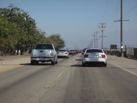 1992 Ford Crown Victoria - A long line of vehicles are stuck in traffic on a sunny day.