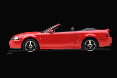 2003 Ford Mustang - This red 2003 Ford Mustang convertible is shown from the side against a black background.