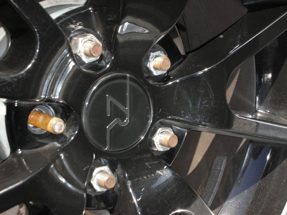 Close-up of a black alloy wheel with a circular center cap a stylized 'ZR' logo and five lug nuts