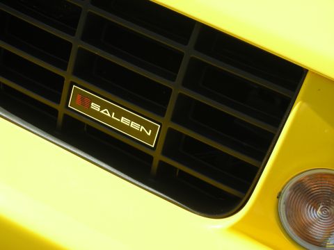 1992 Ford Crown Victoria - Close-up of a yellow car's front grille a prominent Saleen badge.