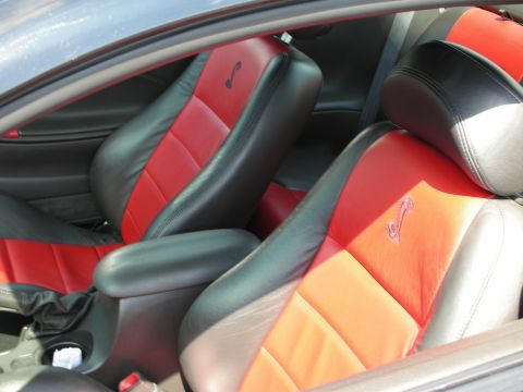 1992 Ford Crown Victoria - Interior view of a car with two-tone red and black seats, a cobra emblem.