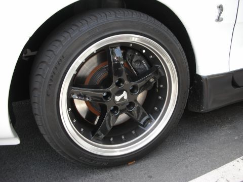 1992 Ford Crown Victoria - A close-up view of a custom wheel and tire assembly, a prominent cobra emblem and high-performance brake caliper.