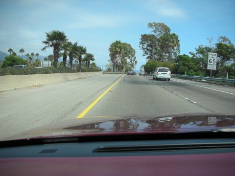 1992 Ford Crown Victoria - A view from the dashboard of a car driving on a highway with a speed limit of 65 mph.