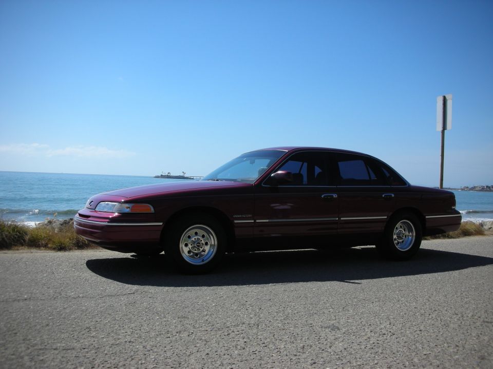 Maroon 1992 Ford Crown Victoria parked by the ocean, side view