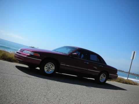 1992 Ford Crown Victoria - Maroon 1992 Ford Crown Victoria parked by the sea under a clear blue sky.