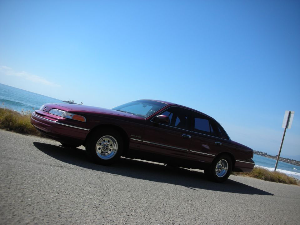 1992 Ford Crown Victoria parked on a road next to the ocean