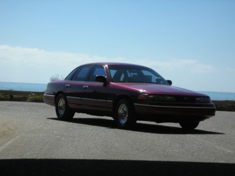 1992 Ford Crown Victoria - Maroon 1992 Ford Crown Victoria parked near the coast under a clear blue sky.