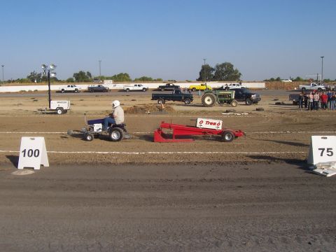 1994 Ford F-150 - A tractor pull event is underway with multiple vehicles and spectators present.
