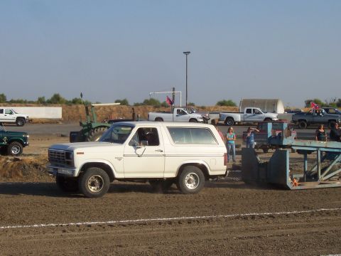 1994 Ford F-150 - A white Ford Bronco participates in a truck pull event, with spectators and other vehicles present.